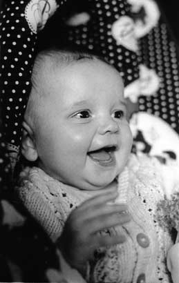 Black and white photo of a grinning baby